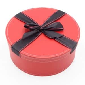 Boite cadeau rouge et ronde avec noeud noir.