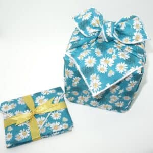 Voici notre emballage cadeau en tissu de type furoshiki de couleur bleue avec motif fleurs.