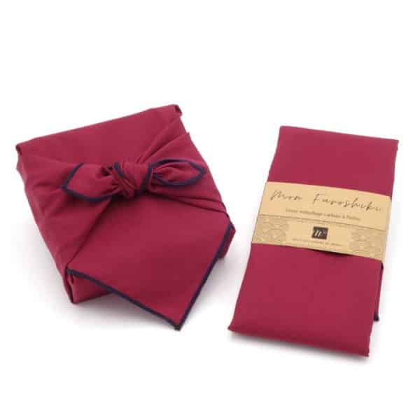 Emballage pour cadeaux en tissu bordeaux. Petit modèle de furoshiki.